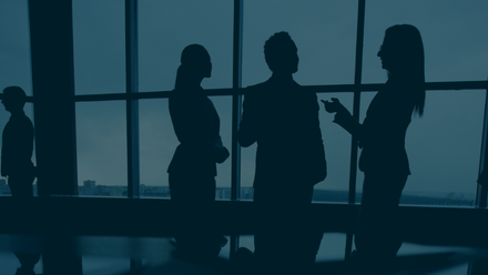 Dark Blue Banner With Professionals Talking to each other in a room