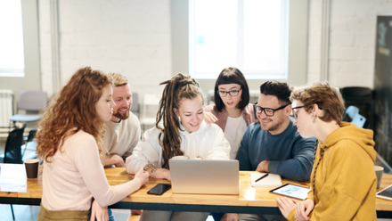 organisation team crowded around a laptop